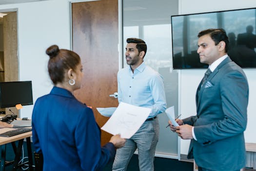 Professional team in a modern office discussing work documents during a meeting.